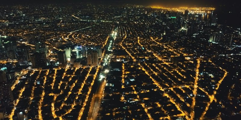 Aerial cityscape at night. Illuminated streets of Manila downtown at traffic route. Urban transport