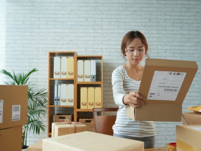 Ethnic woman opening box in post office