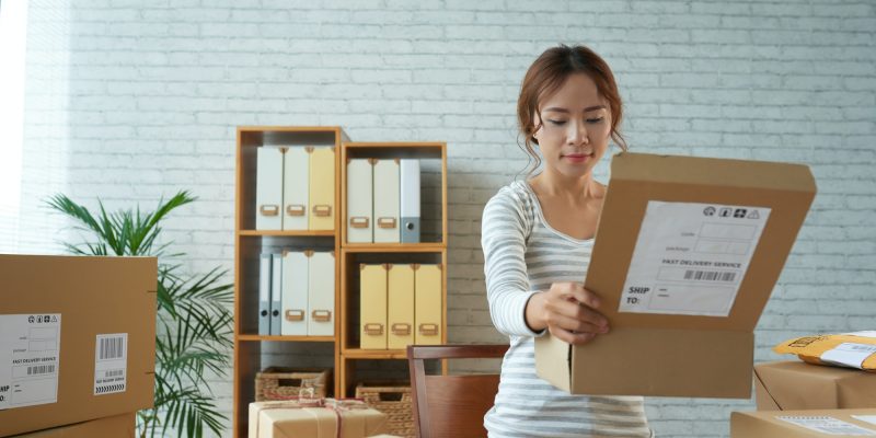 Ethnic woman opening box in post office
